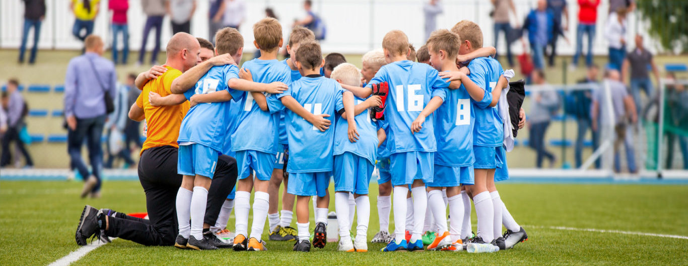 jonge voetballers steken de koppen bij elkaar